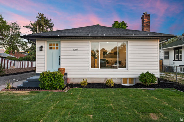189 West Center Street Midvale, UT 84047 - Photo 64 of 64 Single-story residence featuring white siding, a contrasting dark roof, and a prominent brick chimney