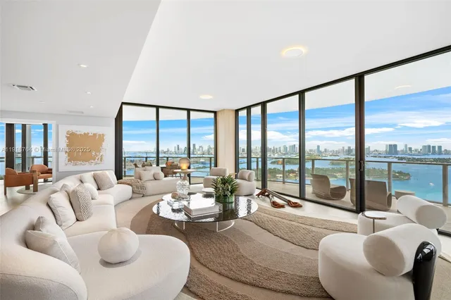 a living room with furniture and floor to ceiling window