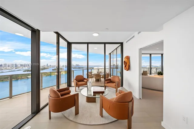 a living room with furniture and a floor to ceiling window