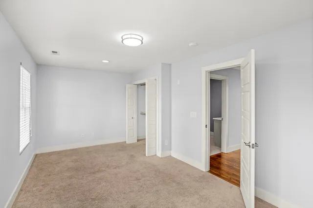 an empty room with windows and closet