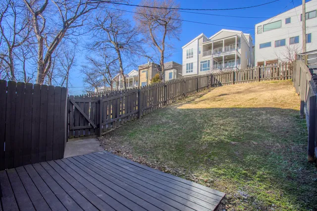 a view of a house with backyard and wooden fence