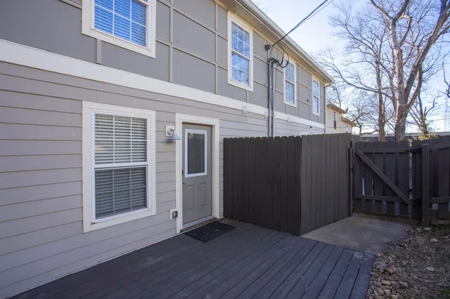 a view of backyard with wooden fence and a large tree