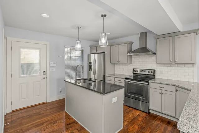 a kitchen with stainless steel appliances granite countertop a sink stove and refrigerator