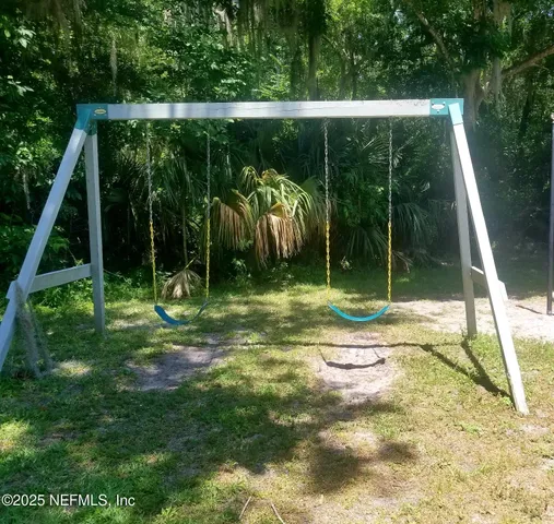 a view of a chairs and table in patio with a yard