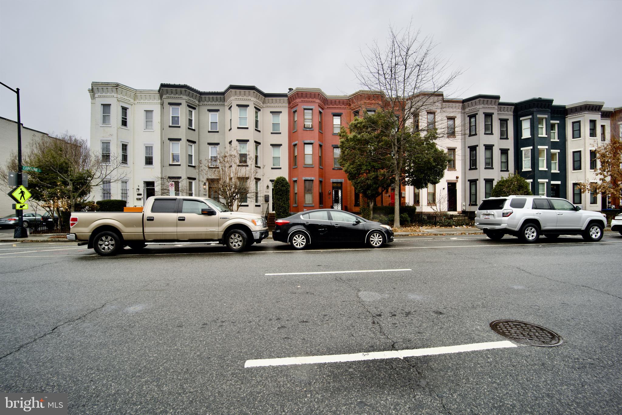 a view of building with cars parked across