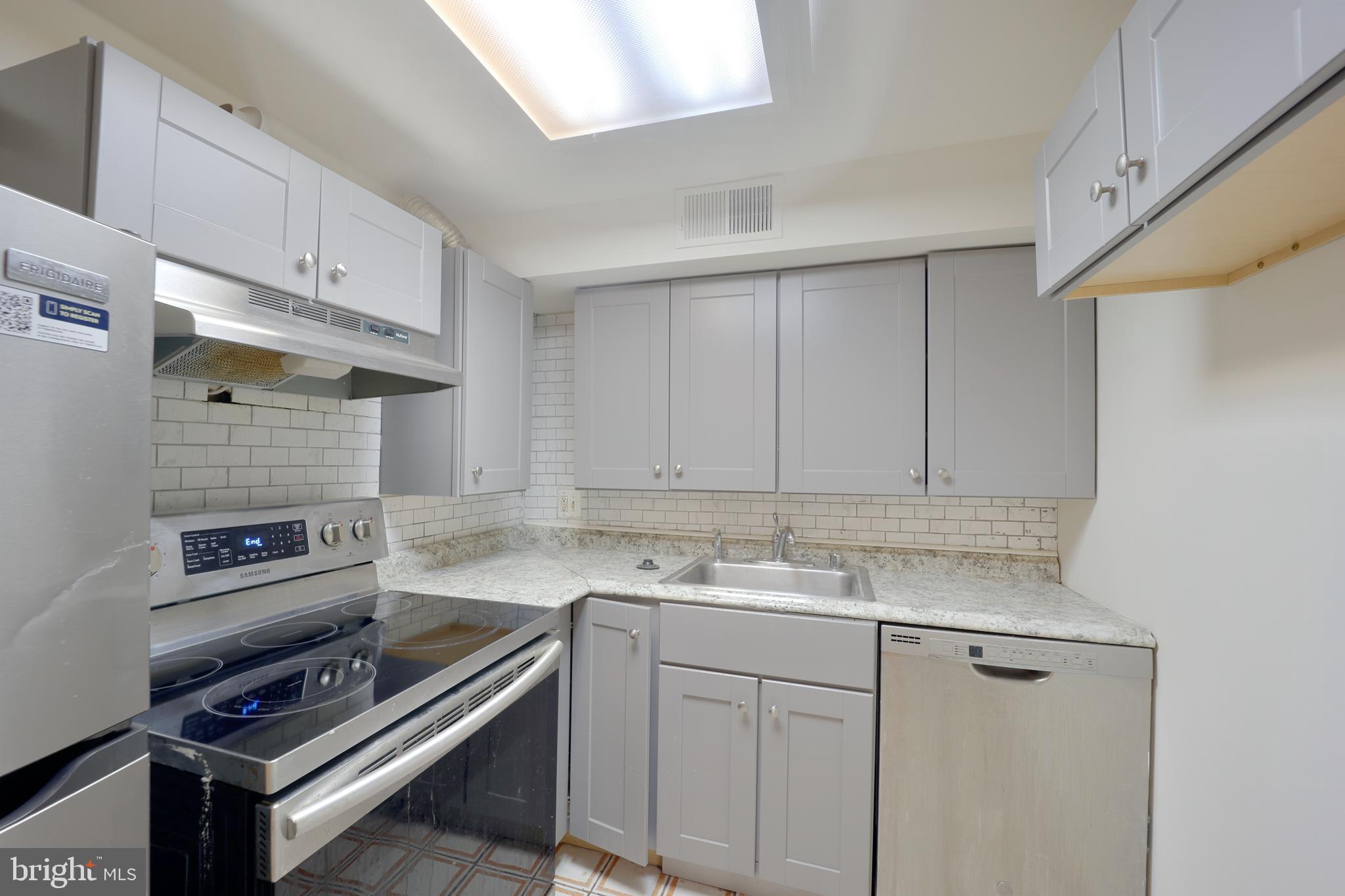 1926 15th Street Northwest, Unit 1 Washington, DC 20009 - Photo 11 of 13 a kitchen that has a sink a stove and cabinets