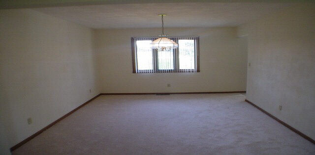 3164 North Trainer Road Rockford, IL 61114 - Photo 3 of 5 an empty room with windows and chandelier