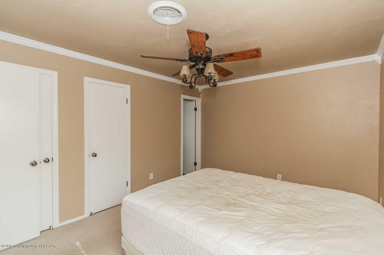 5337 Whitney Lane Amarillo, TX 79110 - Photo 30 of 32 a bedroom with a bed and a chandelier