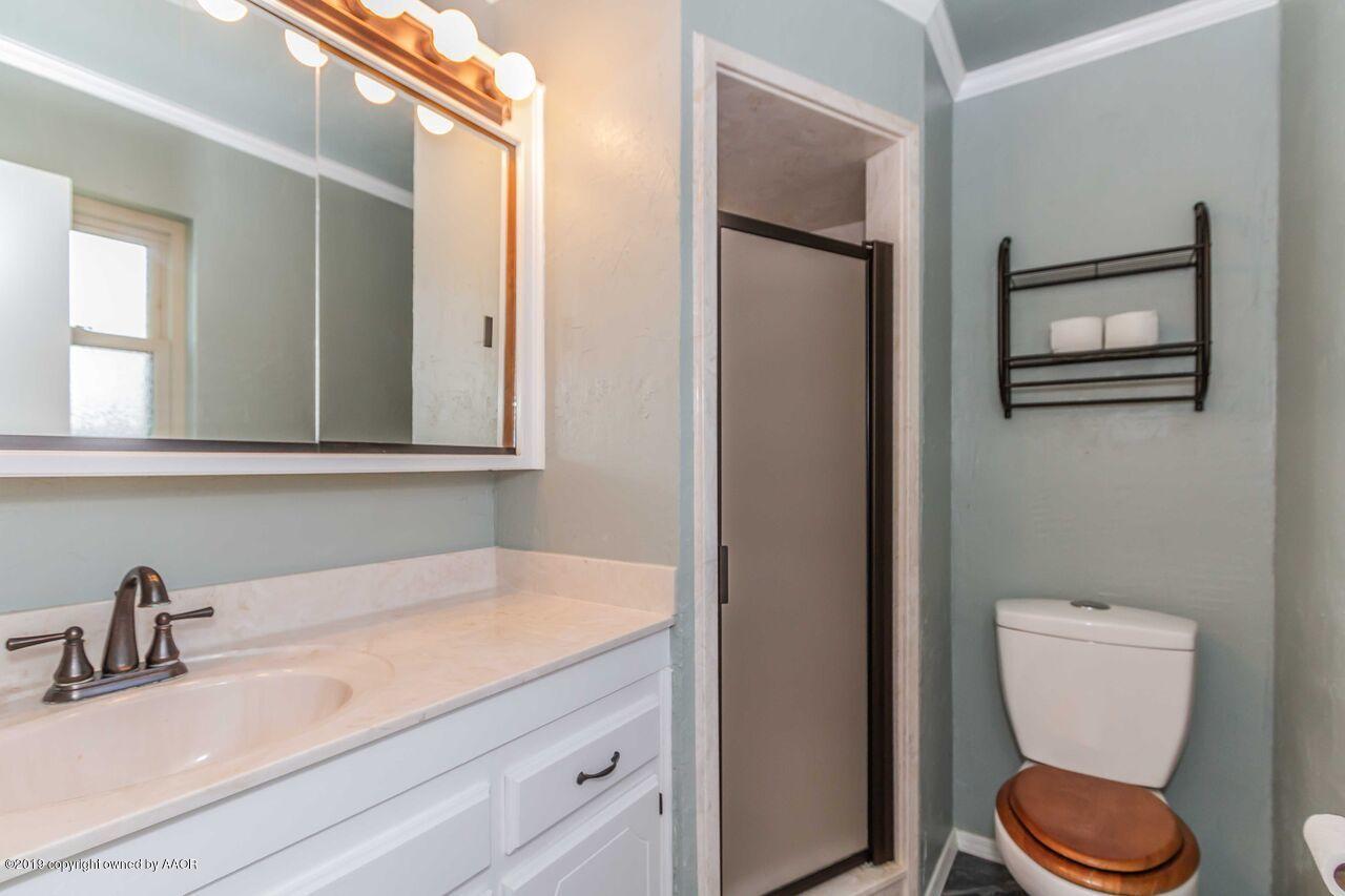 5337 Whitney Lane Amarillo, TX 79110 - Photo 31 of 32 a bathroom with a toilet a sink and mirror