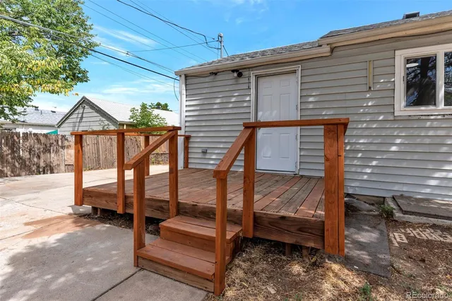 a view of a house with backyard and wooden fence