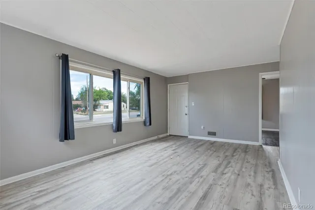 wooden floor in an empty room with a window