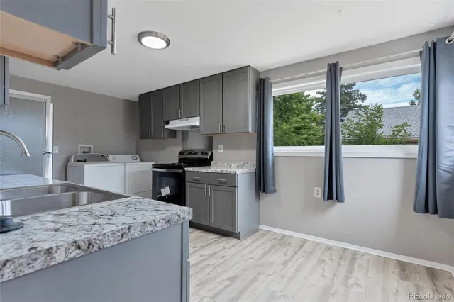 a kitchen with a stove a sink and a refrigerator