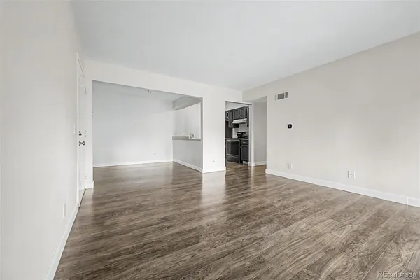 a view of empty room with wooden floor