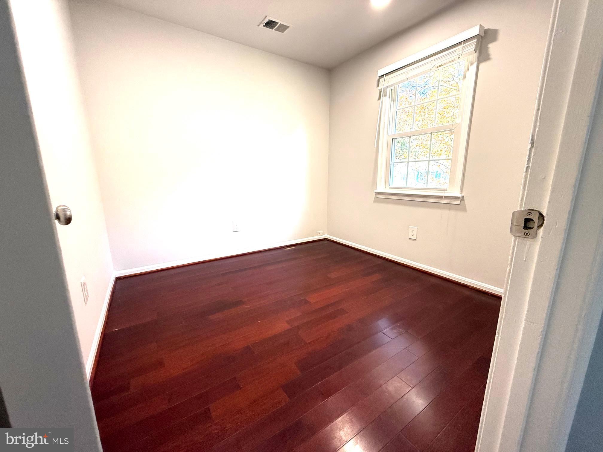 8580 Tyrolean Way Springfield, VA 22153 - Photo 51 of 63 an empty room with wooden floor and windows