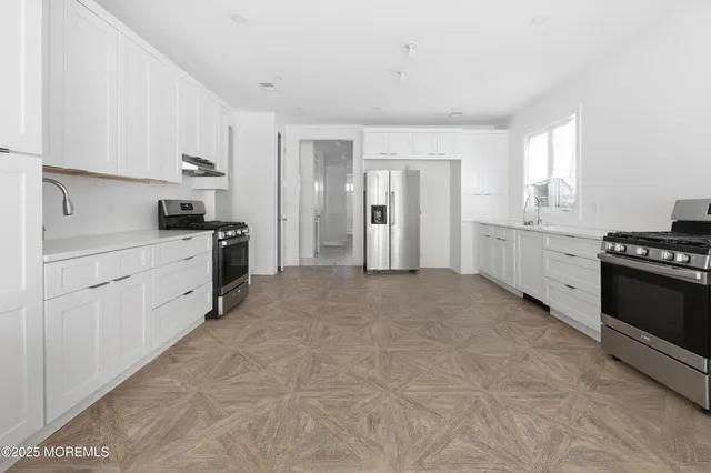 a kitchen with stainless steel appliances a stove sink and cabinets