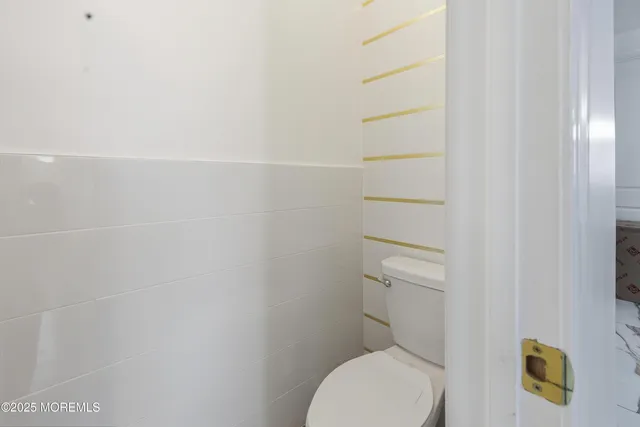 a white toilet sitting next to a shower