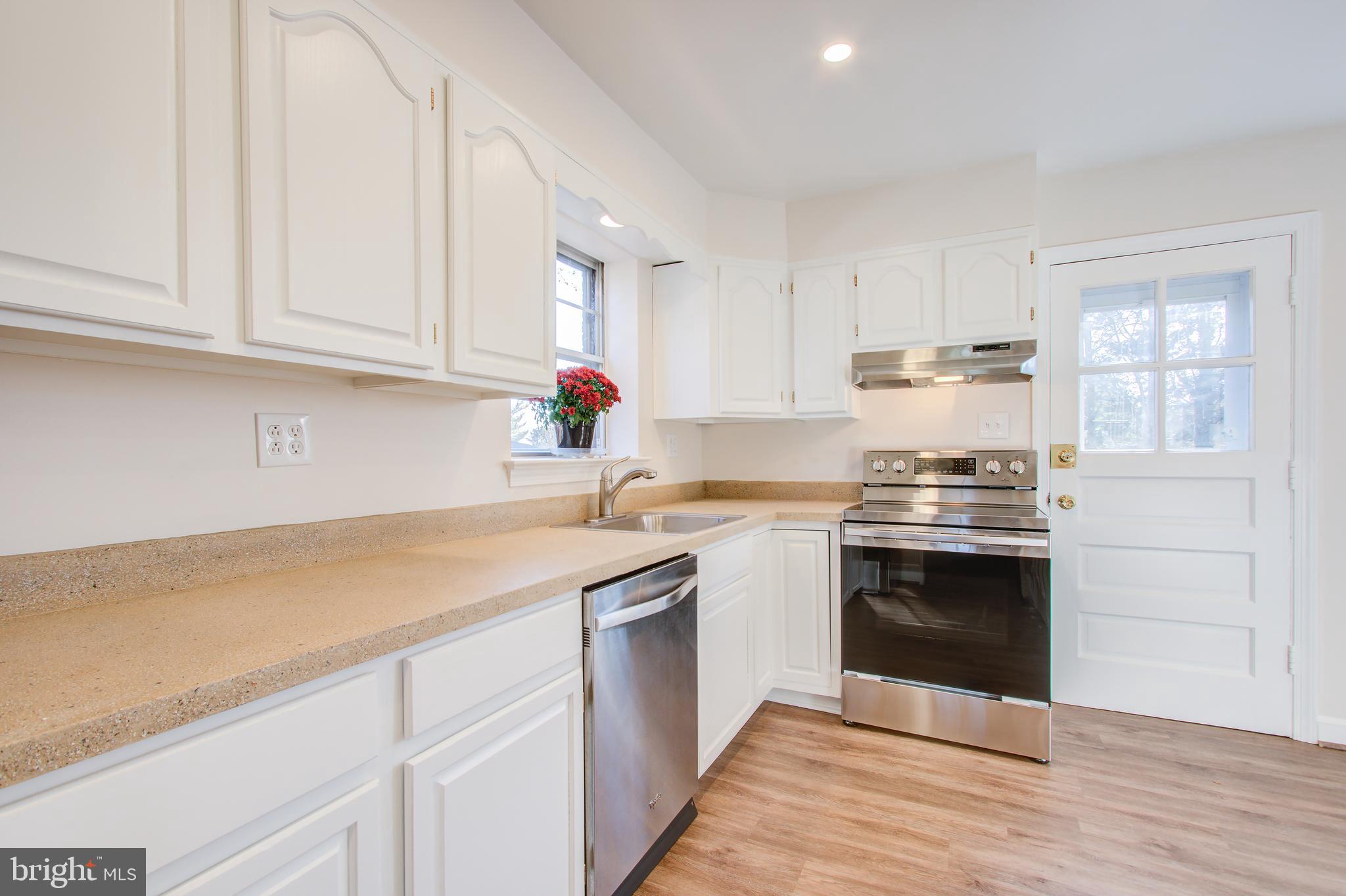1004 Stirling Road Silver Spring, MD 20901 - Photo 11 of 27 a kitchen with stainless steel appliances granite countertop a sink stove and cabinets