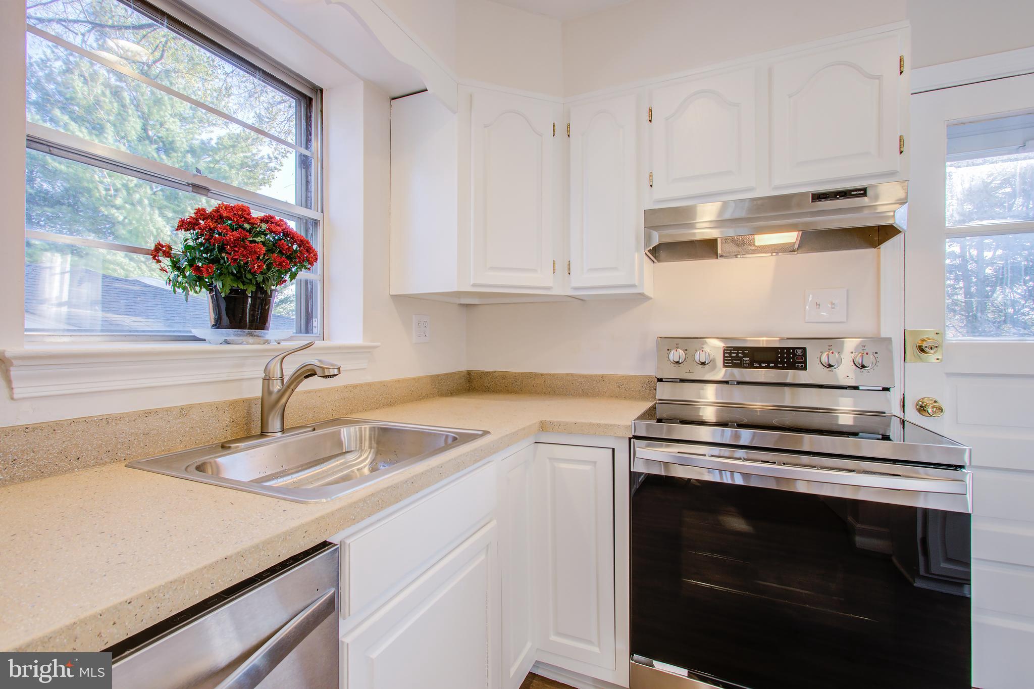1004 Stirling Road Silver Spring, MD 20901 - Photo 12 of 27 a kitchen with a stove microwave and cabinets