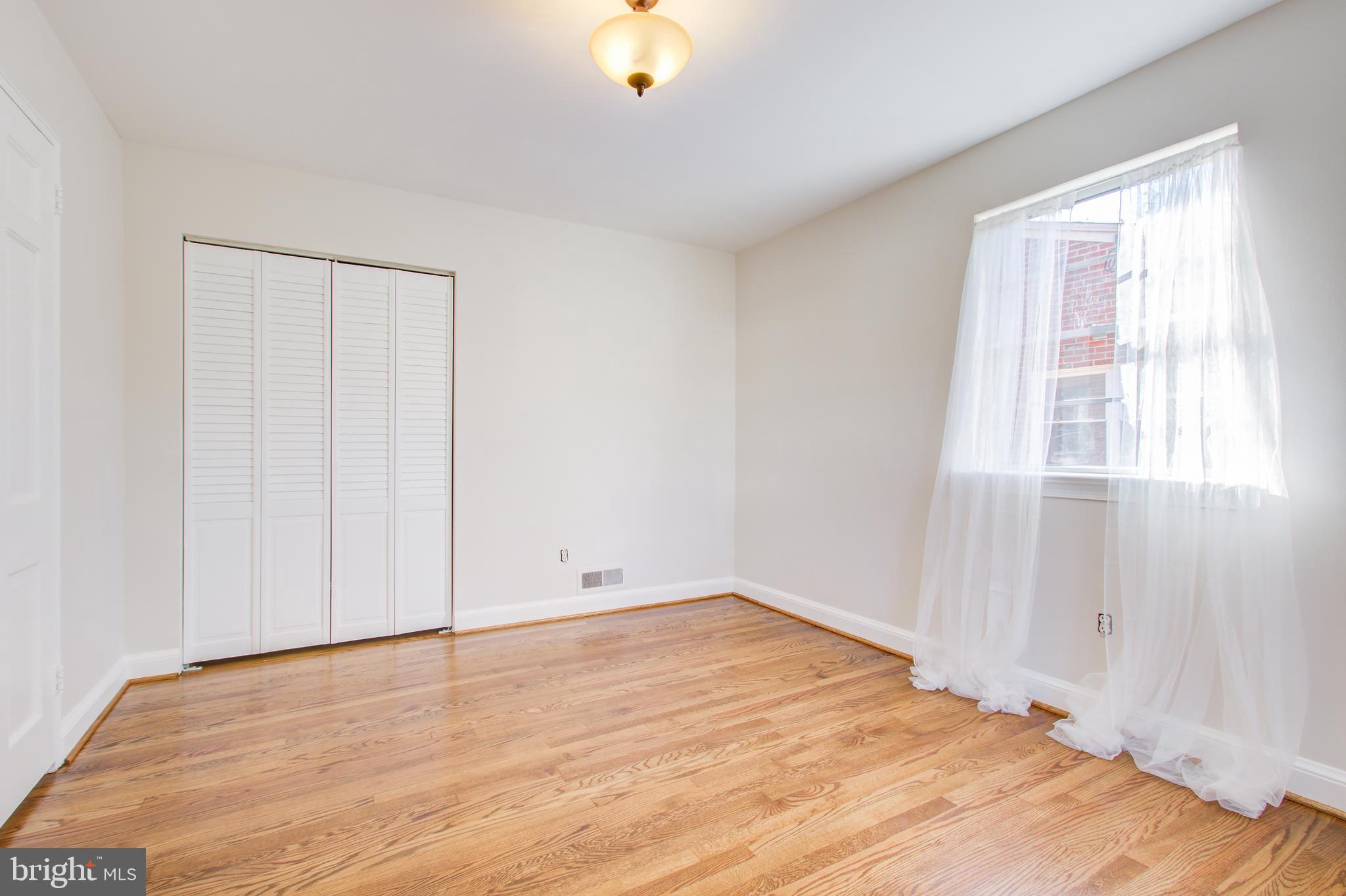 1004 Stirling Road Silver Spring, MD 20901 - Photo 18 of 27 a view of an empty room with wooden floor and a window