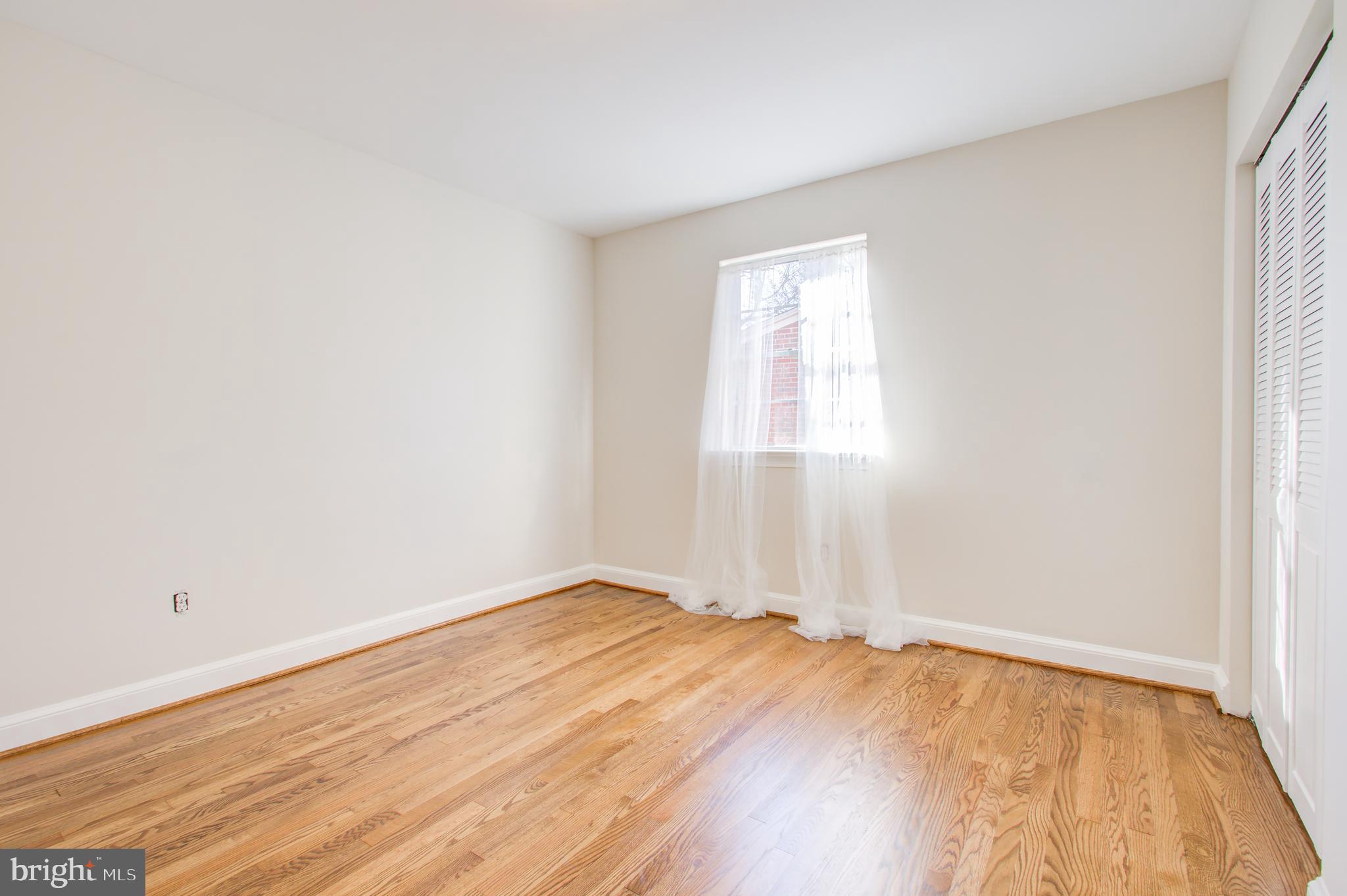 1004 Stirling Road Silver Spring, MD 20901 - Photo 19 of 27 an empty room with wooden floor and windows