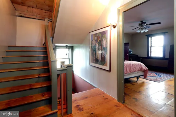 a bedroom with a bed a dresser and chair