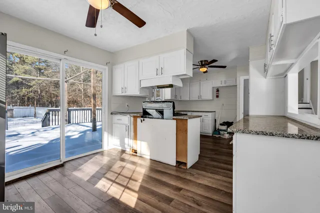 a kitchen with granite countertop a stove a sink and a refrigerator