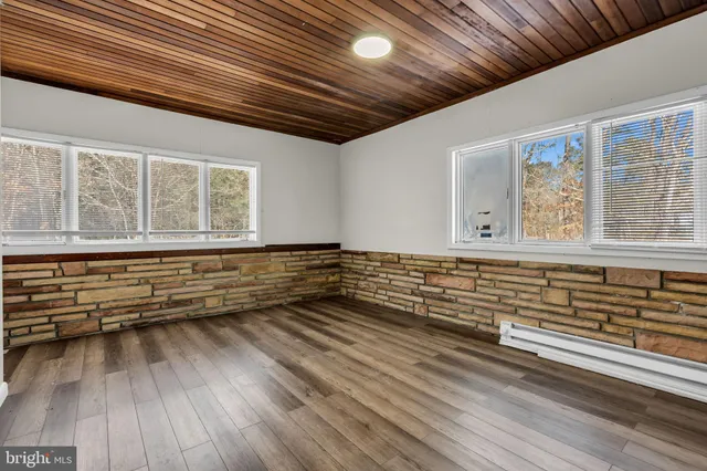 a view of a room with wooden floor and windows