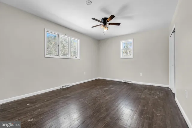 a view of empty room with wooden floor