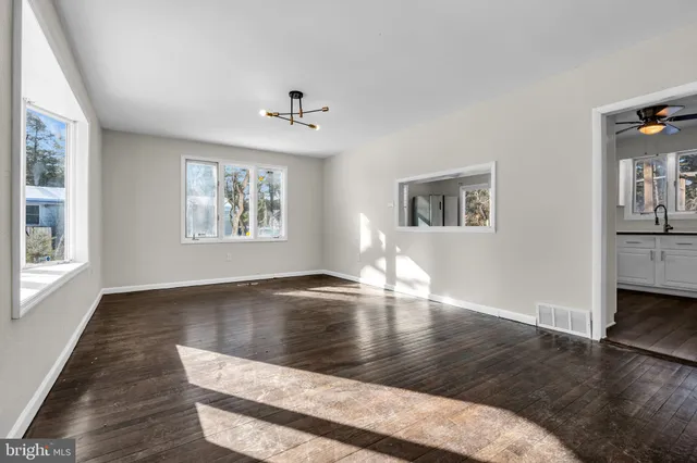 a view of empty room with wooden floor and window