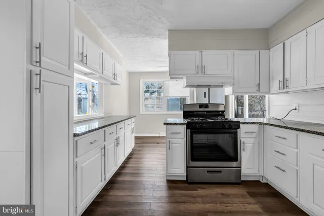 a kitchen with stainless steel appliances white cabinets and a stove