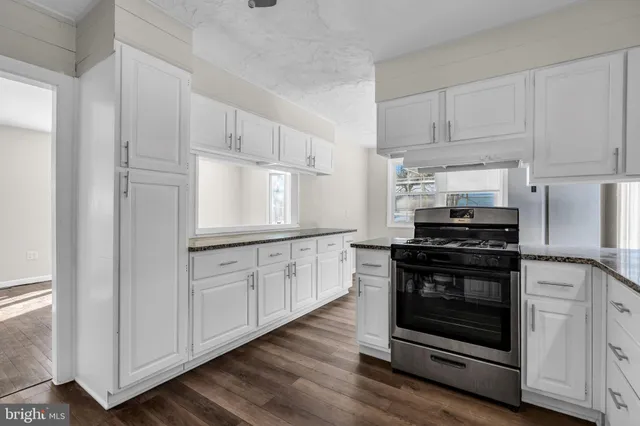 a kitchen with stainless steel appliances white cabinets and a granite counter tops
