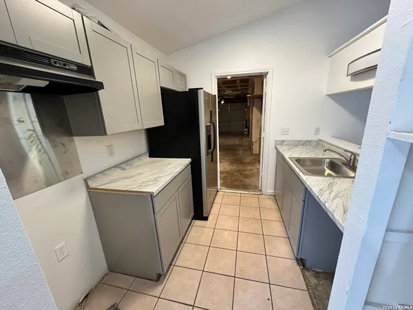 a kitchen with a refrigerator and a sink
