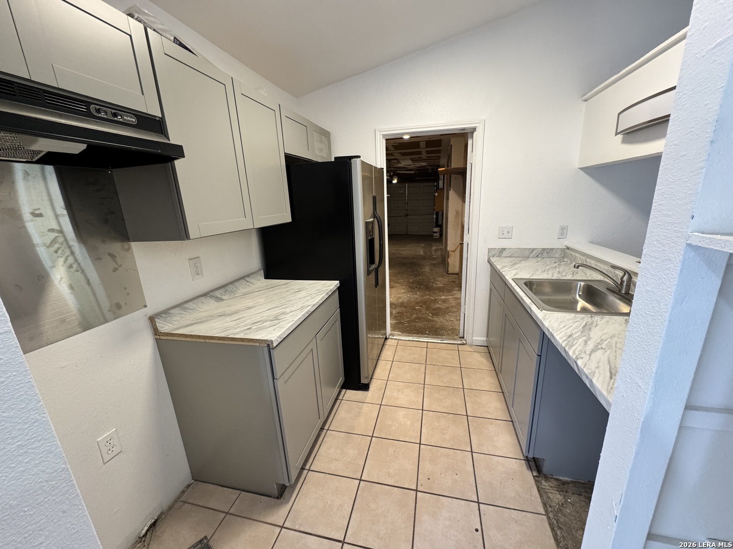 12219 Ridge Crown Street San Antonio, TX 78247 - Photo 7 of 17 a kitchen with a refrigerator and a sink