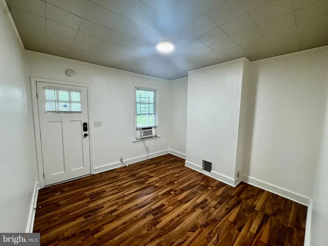 a view of a room with wooden floor and window