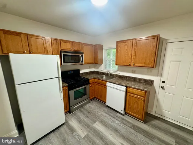 a kitchen with granite countertop stainless steel appliances a refrigerator a stove a microwave and cabinets