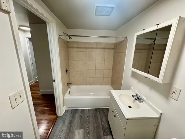 a bathroom with a bathtub a sink a toilet and a shower