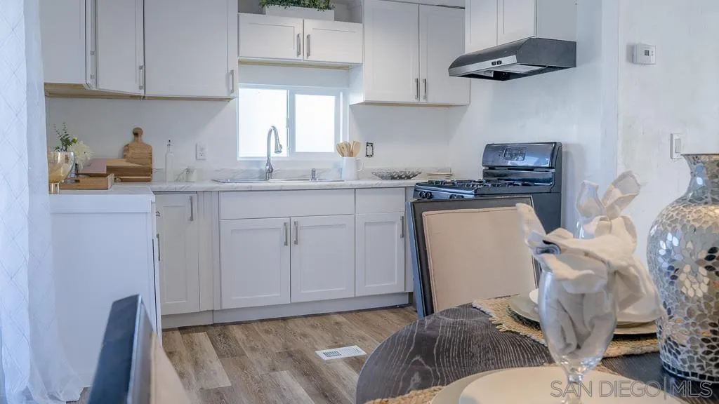 a kitchen with stainless steel appliances granite countertop a sink dishwasher stove top oven and cabinets