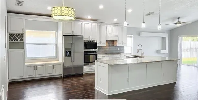 a kitchen with kitchen island granite countertop stainless steel appliances a large counter top space appliances and cabinets