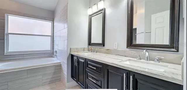 a bathroom with a granite countertop sink and a mirror