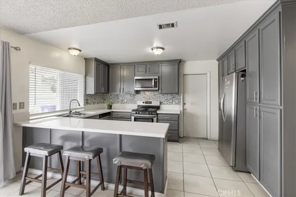 a kitchen with stainless steel appliances granite countertop a stove a sink refrigerator and a refrigerator
