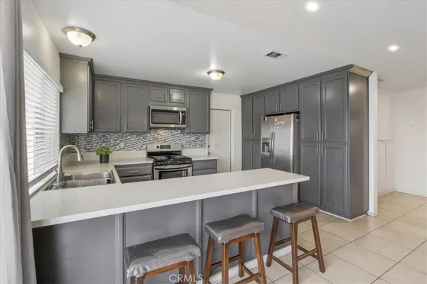 a kitchen with kitchen island a refrigerator stove microwave and cabinets