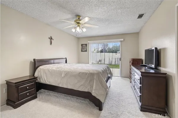a spacious bedroom with a bed and a flat screen tv