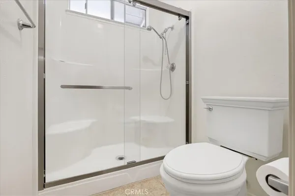 a white toilet next to a bathroom