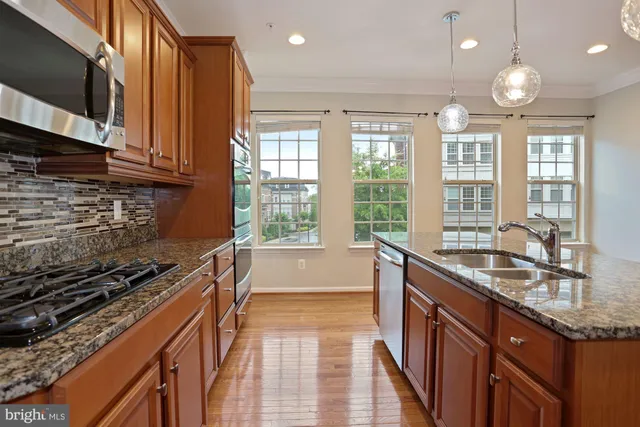 a kitchen with granite countertop a sink stove and cabinets