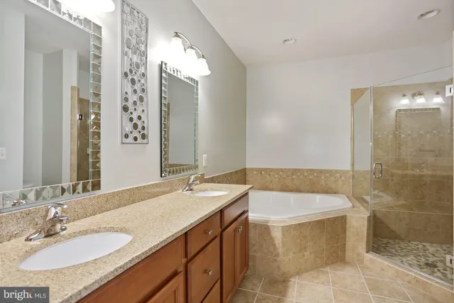 a bathroom with a granite countertop sink a mirror and a bathtub