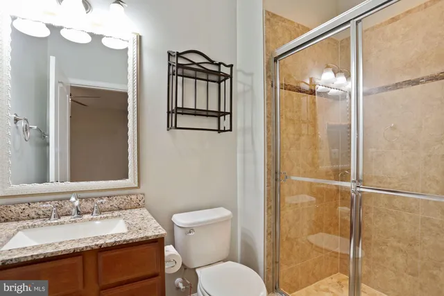 a bathroom with a granite countertop sink toilet and shower