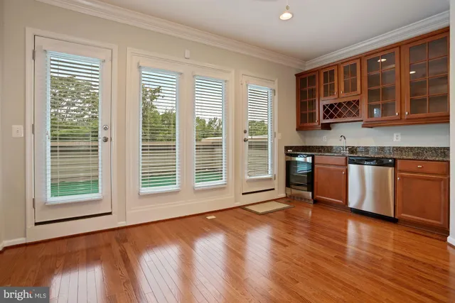 a view of a kitchen with stainless steel appliances granite countertop a stove and a large window