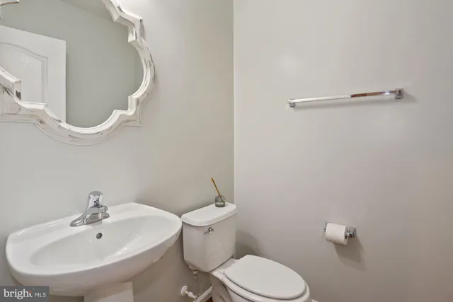a bathroom with a sink a toilet and a mirror