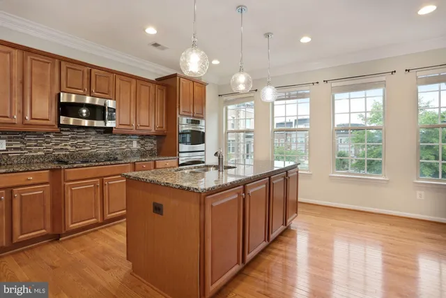 a kitchen with stainless steel appliances granite countertop a sink stove and cabinets