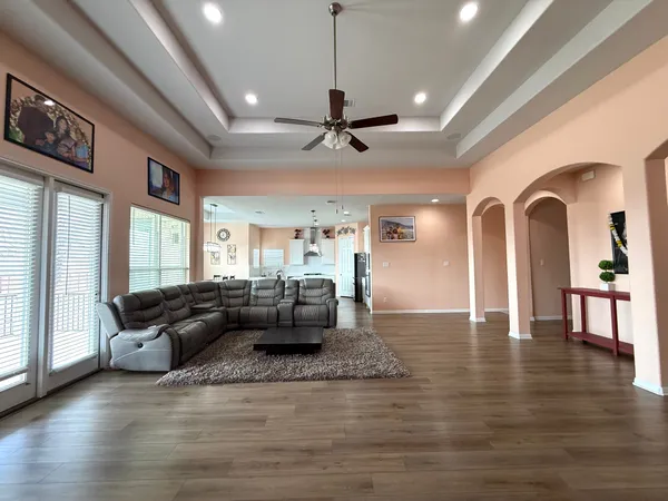 a view of empty room with wooden floor and chandelier